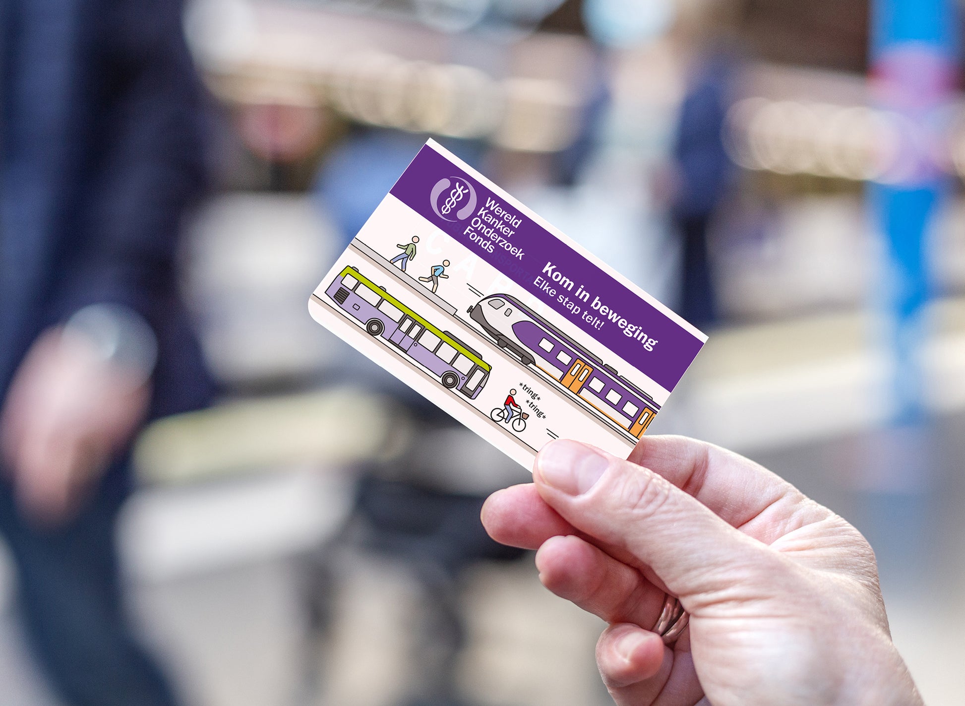 Hand houdt de OV-chipkaarthoes van het Wereld Kanker Onderzoek Fonds vast.